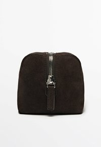 Borsa cosmetica in suede marrone con forma arrotondata, chiusura con zip argentata sulla parte superiore e finitura textura. Design compatto e pratico.