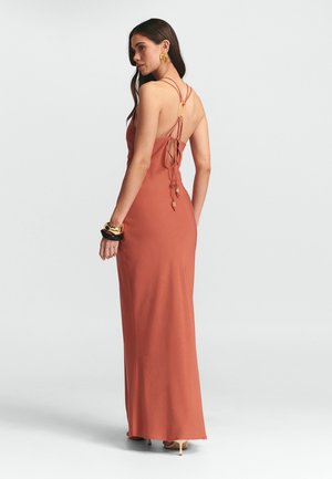 Garšs rūsu krāsas kleita, izgatavota no gludas auduma, ar regulējamiem spaghetti siksnām, zemu aizmuguri un saitēm ar dekoratīviem pērlītēm.