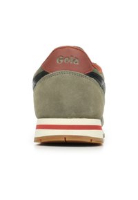 Sneaker in suede grigia con tallone in pelle marrone, dettagli neri e suola bianca a strisce rosse. Logo "Gola" impresso sul tallone.