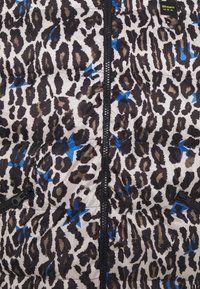 Veste matelassée à imprimé léopard avec fermeture éclair noire, accents étoilés bleus et une petite écusson Blauer U.S.A. près du col.