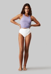 Light purple ribbed tank top with a scoop neckline, paired with high-waisted white briefs featuring a Calvin Klein logo on the waistband.