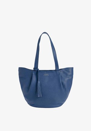 Sac fourre-tout en cuir bleu avec deux longues poignées et un pompon assorti suspendu à une poignée, finition texturée, petit logo doré sur le devant.