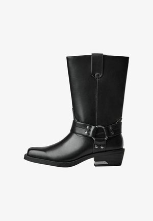 Zwarte leren laars tot aan de knie met een vierkante neus, platte hak en een decoratieve band met metalen accenten rond de enkel. Heeft een gladde textuur.