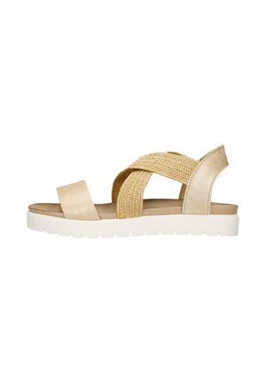 Sandale beige avec des brides tressées texturées et une bande en cuir lisse. Semelle confortable en cuir doux sur une épaisse semelle blanche.