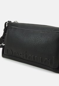 Schwarze, strukturiertes Leder-Crossbody-Tasche mit geprägtem Logo-Detail, Reißverschluss und verstellbarem Riemen. Glatte Oberfläche mit subtiler Glanz.