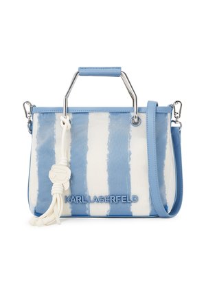 Sac à main à rayures bleues et blanches avec poignée en métal, bandoulière amovible, pendentif à pompons blancs et logo "KARL LAGERFELD" à l'avant.