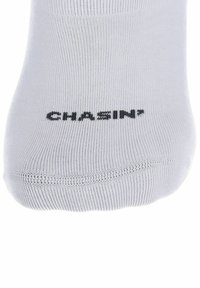 Calzino bianco in cotone con texture a costine e punta rinforzata, con il testo stampato "CHASIN'" in nero sul lato superiore.