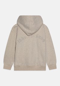 Felpa beige con cappuccio, realizzata in tessuto morbido. Presenta polsini e orlo a coste. Testo stampato in una tonalità più scura sul retro.