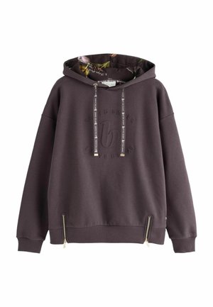 Donkerpaarse hoodie met bloemmotief aan de binnenkant van de capuchon, koordjes met tekst, reliëflogo aan de voorkant en twee kleine ritsen bij de zoom.