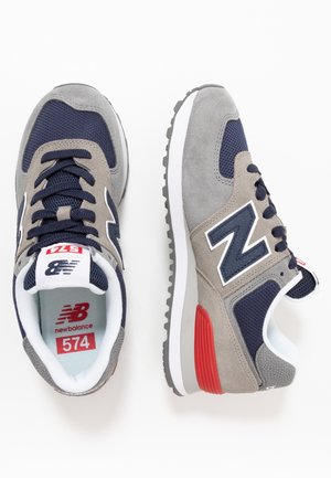 Gray and navy suede sneakers with mesh accents, featuring a prominent white "N" logo and red heel detail. Rubber sole for traction.