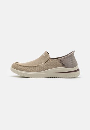 Beige slip-on sko med tekstureret mesh-overdel, rundet tå og let gummisål. Indeholder et åndbart design med en grå quiltet bagaccent.