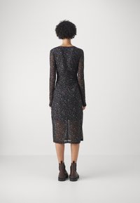 Mustikka kukkakuosiset mekko pitkillä hihoilla, rypytetty yksityiskohta takana, puoliväritön kangas, polven mittainen, yhdistetty tummiin nilkkasaappaisiin.