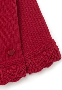 Roter, gestrickter Schal mit strukturiertem Muster, abgeschlossen mit einem gewellten Rand und einem kleinen, herzförmigen Etikett, das mit "Liebe" geprägt ist.