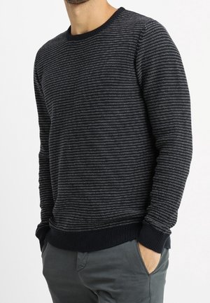 Granatowy sweter wykonany na drutach z poziomymi paskami, z prążkowanym dekoltem i mankietami oraz miękką fakturą. Posiada swobodny, prosty krój.