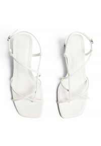 Weiße Riemchensandalen mit quadratischer Zehenform, aus glattem Leder, dünnen Riemen und verstellbaren Schnallen am Knöchel.