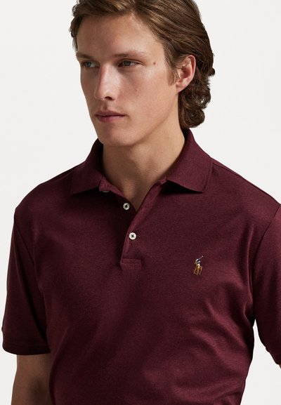 Polo de culoare burgundy, fabricat din bumbac, cu un guler clasic, placket cu trei nasturi și un logo brodat cu un cal pe piept.
