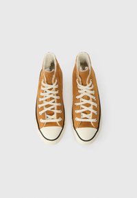 Μποτάκια υψηλής κοπής από καφέ σουέντ με λευκές κορδόνες, κρεμ καουτσούκ στα δάχτυλα και μαύρες λεπτομέρειες. Υφασματική υφή και επενδεδυμένος γιακάς.