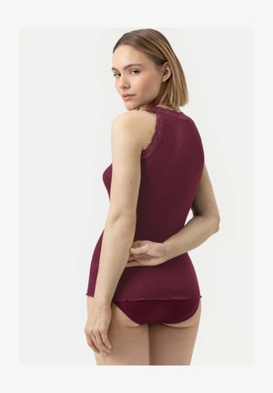 Top in jersey bordeaux a coste con dettagli in pizzo sulle spalle, di forma aderente e con un orlo scallop sottile; abbinato a pantaloni corti coordinati.