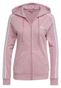 Sudadera rosa con cremallera hecha de un tejido suave, que cuenta con una capucha, franjas blancas en las mangas y bolsillos frontales. Logo de la marca en el pecho.