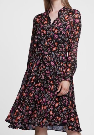 Robe noire à fleurs avec des manches longues, un col froncé, une taille froncée et des imprimés colorés en rouge, violet et bleu. Tissu fluide.