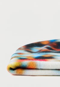 Šarena rebrasta pletena kapa s mekim teksturama. Ima gradijentni uzorak plavih, narančastih i ružičastih nijansi. Preklopljeni rub za bolju pristajanje.