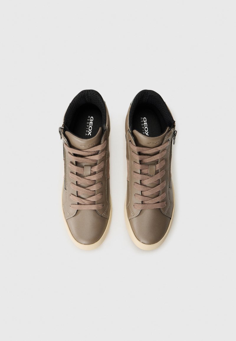Beige lage sneakers met veters, zijritsen, zwarte binnenvoering en witte zolen, naast elkaar op een witte achtergrond gerangschikt.