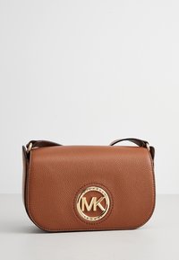 Borsa a tracolla in pelle marrone con superficie strutturata, un logo circolare dorato come dettaglio e una forma piatta e arrotondata. Tracolla regolabile inclusa.