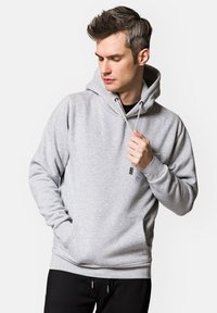 Szara bluza z kapturem, z kieszenią kangurzą, sznurkami i ściągaczami na rękawach. Wykonana z miękkiego, teksturowanego materiału dla komfortu.