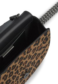 Tasje met luipaardprint en een zwarte leren bovenkant, een kettingriem en een magnetische sluiting. Het interieur heeft een creditcardvak en een gladde textuur.