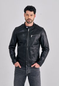 Černá kožená bunda s límcem, s předním zapínáním na zip a zipovými kapsami na hrudi a boku. Hladká textura, přiléhavý střih.