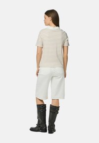 Lentes ar svītrām īsām piedurkn�ēm ar baltu apkakli, baltas denimu šorti un melnas ādas zābakus līdz ceļiem ar sprādzēm un zemu papēdi.