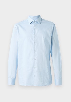 Lyseblå langærmet skjorte lavet af bomuld. Har en krave med knapper, en centreret knaplukning og en diskret logoaccent på brystet.