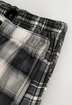 Pantaloni lounge a quadri in nero, grigio e bianco. Tessuto morbido con vita elastica e vestibilità rilassata, caratterizzati da un motivo testurizzato.