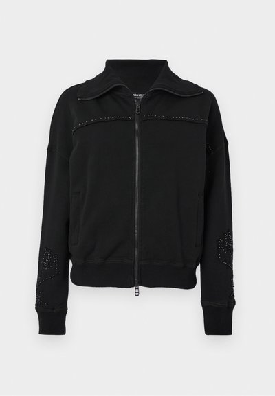 Sweat-shirt zippé noir avec un col haut, présentant des accents cloutés, une texture lisse et des poches latérales. Poignets et ourlet côtelés.
