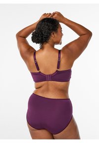 Vijolična perilo komplet, ki vsebuje modrček z nastavljivimi naramnicami in zadaj zaponkami, dopolnjen s hlačkami z visokim pasom in valovitimi robovi.