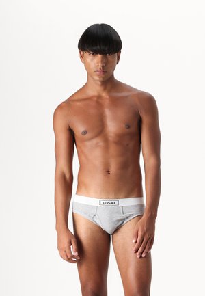 Graue Baumwollunterhosen mit einem weißen elastischen Bund, der das "VERSACE"-Logo trägt, und einem figurbetonten Design sowie subtiler Textur.
