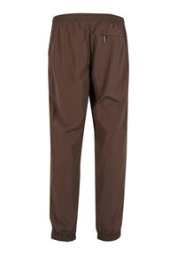 Brązowe, lekkie spodnie wykonane z materiału ripstop, z elastycznym paskiem w talii, kieszeniami bocznymi i elastycznymi mankietami dla pewnego dopasowania.