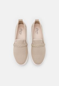 Beige Leinen-Slipper mit geflochtenem Akzent über dem oberen Teil, runder Zehenform und weißer Gummisohle.