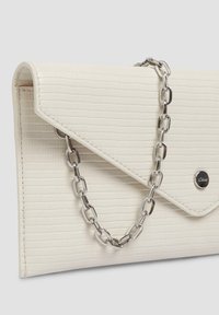 Pochette blanche texturée avec une bandoulière chaîne argentée, dotée d'un rabat et d'un petit logo métallique.