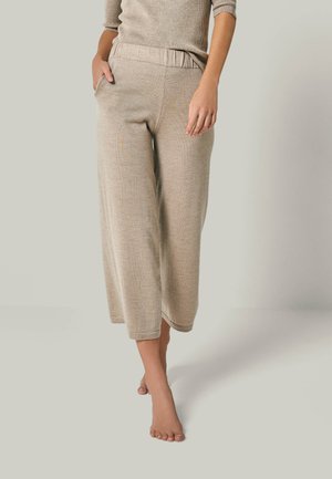 Beige weite Hose mit elastischem Bund, texturiertem Stoff und seitlichen Taschen. Saumgesäumte Bündchen, knöchellanges Design.
