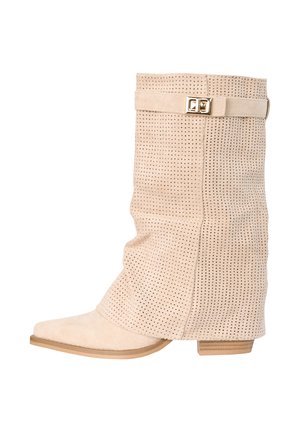 Beżowy zamszowy botek do połowy łydki z perforowanym wzorem, szpiczastym noskiem, niskim obcasem na blok i ozdobnym paskiem z złotą klamrą u góry.