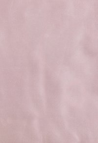 Tissu rose doux avec une texture lisse et légèrement brillante et un subtil motif diagonal. Le matériau semble léger et flexible.