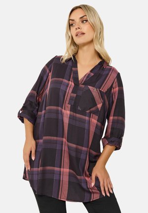 Camicia a quadri nei toni del nero, viola e rosa; vestibilità comoda con scollo a V, maniche arrotolate e taschino sul petto; tessuto testurizzato.