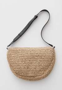 Halbmondförmige geflochtene Strohtasche mit strukturiertem Muster und verstellbarem schwarzem Lederschulterriemen.