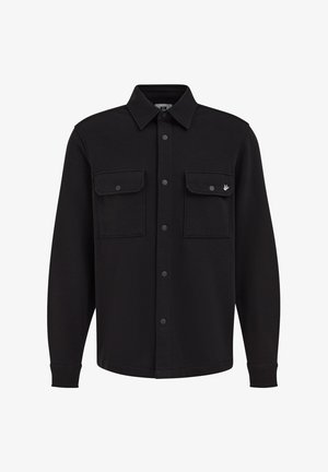 Camicia giacca nera a maniche lunghe con chiusura a bottoni, due tasche con patta sul petto e un piccolo logo a forma di uccello sulla tasca destra.
