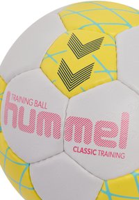 Palla da allenamento con una combinazione di colori bianco, giallo e blu. Presenta una superficie texturizzata, pannelli esagonali e loghi stampati in rosa e nero.