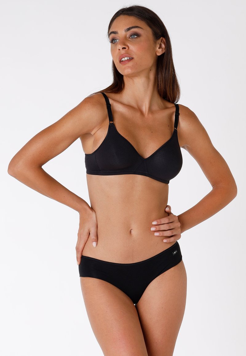 Reggiseno nero con sottili spalline regolabili e tessuto liscio, abbinato a perizoma bikini neri a vita bassa. Design minimalista, senza motivi.