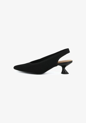 Zapato de tacón slingback negro texturizado con punta puntiaguda y tacón bajo acampanado único sobre fondo blanco.