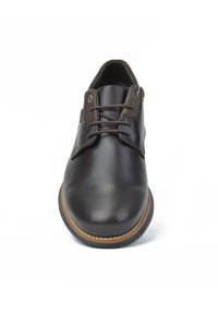 Zapato de cuero marrón con un acabado suave, punta redonda, cordones de dos ojal y una suela cosida de color marrón claro. Diseño plano con un detalle mínimo.