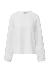 Biała bluzka z dekoltem w serek i długimi rękawami. Rękawy mają teksturowany wzór przypominający siatkę na mankietach. Gładka tkanina na całej powierzchni.
